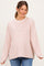 woman wearing a light pink and white striped maternity top with relaxed fit and side slits, smiling at the camera