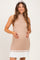 woman wearing a beige ribbed maternity dress with white striped hem and holding her baby bump