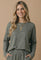 woman wearing a gray striped long sleeve top with a loose fit and relaxed neckline
