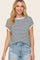 woman wearing a striped short sleeve top with rolled cuffs and distressed denim shorts