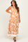 woman wearing an orange floral print maternity maxi dress with a fitted empire waist and flowy skirt, showing her baby bump