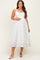 woman wearing a white maternity dress with blue floral print and spaghetti straps, showcasing her baby bump