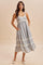 woman wearing a light blue floral print sundress with adjustable straps and pockets