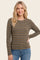 woman wearing a brown and gray striped long sleeve top with a crew neckline and a relaxed fit paired with blue jeans