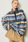 woman wearing a blue and tan striped fleece pullover with a half zip and relaxed fit, paired with a beige skirt