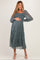 woman wearing a teal floral maternity dress with puffed sleeves, holding her baby bump