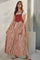 woman wearing a rust-colored striped maxi dress with a white t-shirt underneath and holding the skirt lightly