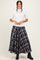 woman wearing a white short sleeve top and a long navy plaid skirt with black boots