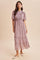 woman wearing a pink floral maxi dress with puff sleeves and tiered ruffles