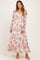 woman wearing a floral long sleeve maternity maxi dress with a tie at the waist and a visible baby bump
