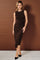 woman wearing a chocolate brown sleeveless dress with a twist detail at the waist and black pointed toe heels