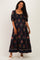 woman wearing a black floral maternity maxi dress with puff sleeves and a square neckline, displaying a baby bump