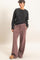 woman wearing a black ribbed sweater and dusty pink wide-leg pants with an elastic waistband and side pockets