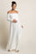 woman wearing a white off-shoulder maternity dress and holding her baby bump