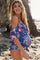 smiling pregnant woman in blue floral maternity swimsuit at the beach