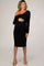 woman wearing a black one-shoulder maternity dress and holding her baby bump