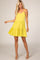 woman wearing a bright yellow spaghetti strap sundress with a flared skirt and tiered design