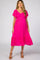 woman wearing a bright pink short sleeve maternity dress with a tiered skirt and a v-neckline, showing her baby bump