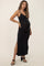 woman wearing a black ribbed maternity maxi dress with side slits and a visible baby bump