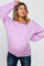 woman wearing a lavender oversized maternity sweater and showing her baby bump