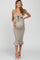 woman wearing a beige maternity dress with a knot front and ruffled hem, highlighting her baby bump