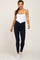 woman wearing navy blue crossover maternity leggings and a white camisole tank top with white sneakers