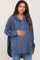 woman wearing a blue maternity hoodie with a button-up front and pockets, gently holding her baby bump