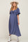woman wearing a blue maternity dress with a front tie detail and flutter sleeves, showcasing her baby bump