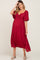 woman wearing a red maternity dress with a tie front, short flutter sleeves, and a baby bump visible