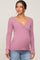 woman wearing a pink long sleeve maternity wrap top and showing her baby bump