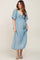 woman wearing a light blue maternity dress with a tie front and flowy sleeves, showing her baby bump