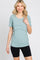 woman wearing a teal short sleeve top with a layered design and black bike shorts