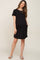 woman wearing a black short sleeve maternity dress with pockets and a baby bump visible