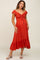 woman wearing a rust red maternity dress with a ruched bodice and flutter sleeves, showing her baby bump