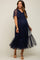 woman wearing a navy blue maternity dress with short flutter sleeves and a sheer tiered skirt, highlighting her baby bump