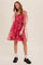 woman wearing a pink floral organza puff sleeve mini dress with black loafers and white lace socks