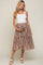 pregnant woman in white tank top and floral maternity midi skirt holding her baby bump