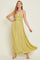 woman wearing a flowy light green maxi dress with a lace bodice and adjustable straps, posing elegantly