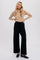 woman wearing tan long sleeve crewneck top and black wide leg knit trousers with loafers