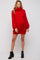 woman wearing a red oversized knit maternity dress with a high neck and balloon sleeves, showing her baby bump