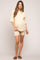 woman wearing a cream ribbed maternity short set with a visible baby bump