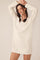 woman wearing a cream oversized knit sweater dress with a v-neck and long sleeves