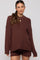 woman wearing a rust ribbed maternity sweater with oversized sleeves and a relaxed fit, paired with matching shorts