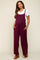 woman wearing a burgundy maternity jumper with wide legs and pockets over a white t-shirt, showcasing her baby bump