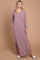 woman wearing a mauve long sleeve maxi dress with side slits and pockets, standing on a beige background