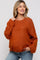 woman wearing an orange oversized maternity sweater with long sleeves and a relaxed fit, smiling