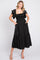 woman wearing a black maxi dress with ruffled sleeves and pockets, smiling and posing against a white background