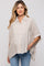 woman wearing a beige and cream striped maternity shirt with a button-up front and loose sleeves
