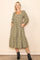 woman wearing a green and beige gingham patterned long sleeve midi dress with a square neckline and pockets