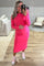 woman wearing a bright pink long sleeve maternity dress and showing her baby bump while taking a selfie in a mirror